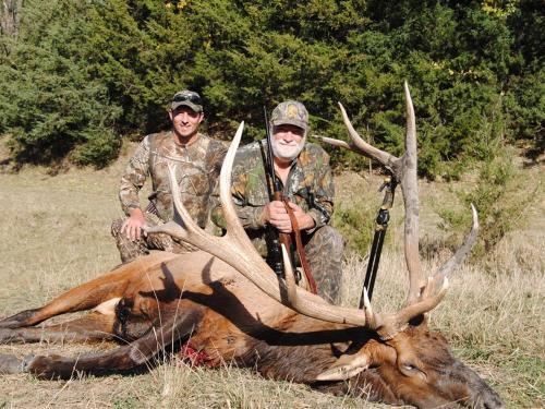 Two men next to dead elk