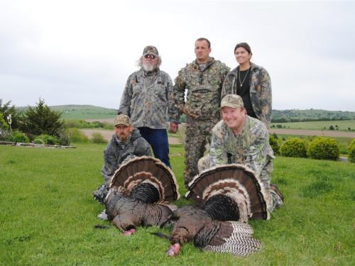 Four people with two hunted turkeys